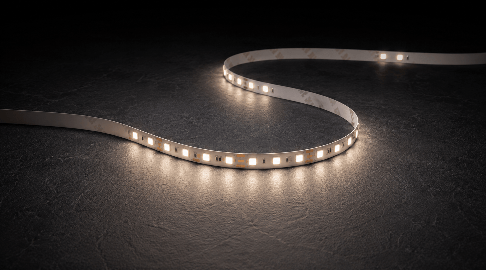 The light strip laid in a curve on dark slate, lit neutral white