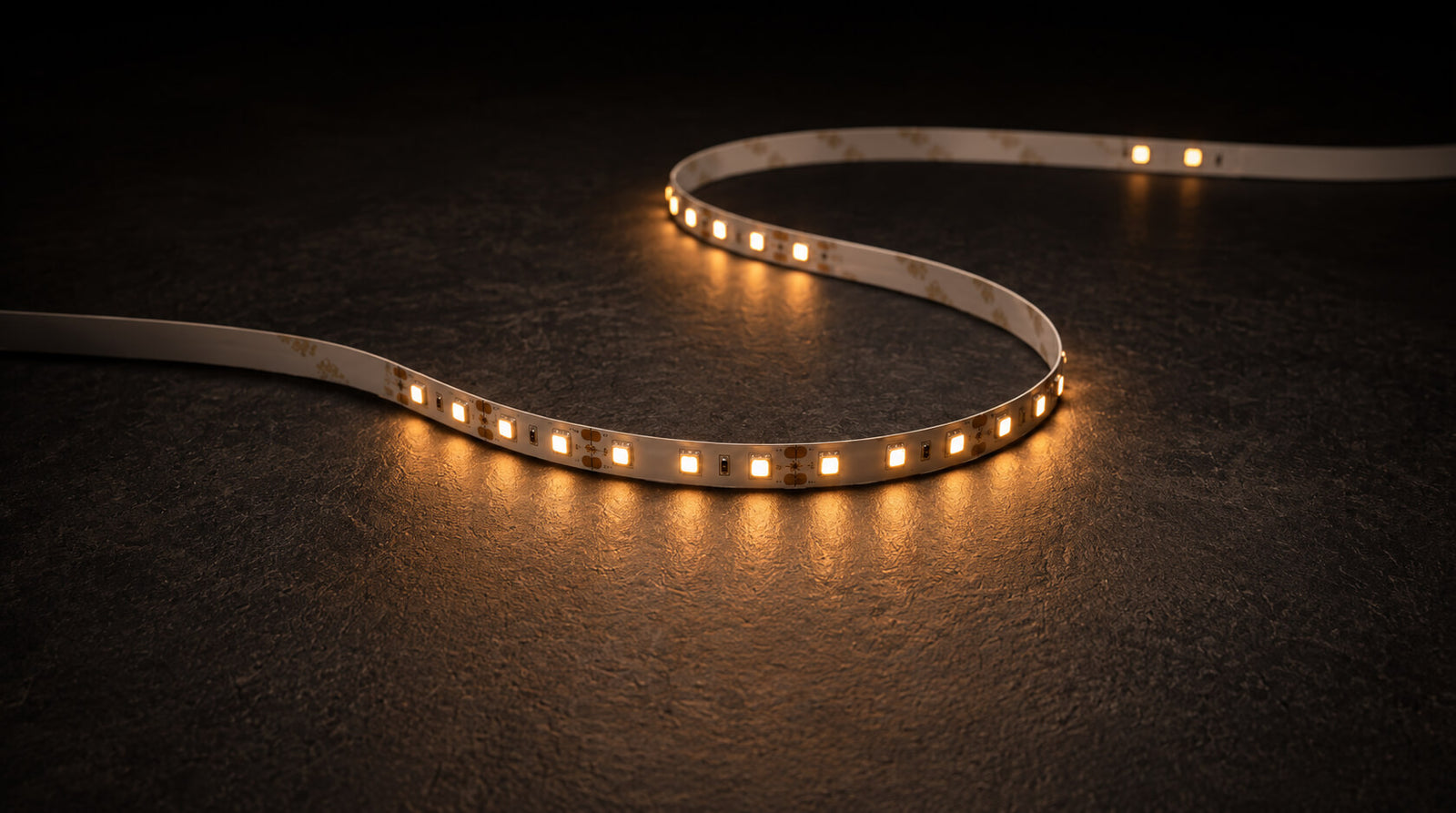 The light strip laid in a curve on dark slate, lit warm white